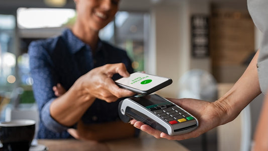 middle-aged woman paying on the counter using Apple Pay